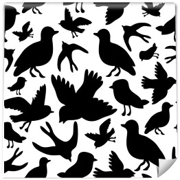 Czarne sylwetki lecących ptaków na białej płaszczyźnie