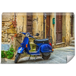 Niebieski skuter na ulicy na starym mieście w Toskanii