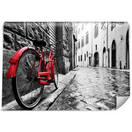 Retro czerwony rower na chodniku w starym miasteczku