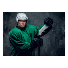 Gracz w hokeja w odzieży ochronnej trzymający kij
