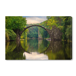 Odbijający się most w tafli rzeki w Parku Kromlau w Niemczech