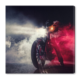 Motocyklista w nocy w kłębach dymu