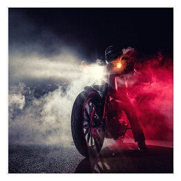 Motocyklista w nocy w kłębach dymu