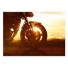 Koło motocyklu na tle złocistego zachodu słońca
