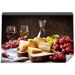 Wino, winogrona i ser na stole w ciemnym pomieszczeniu