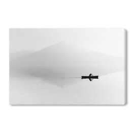 Mgła nad jeziorem z sylwetką mężczyzny na łodzi