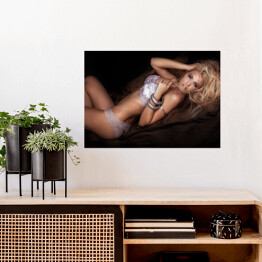 Plakat samoprzylepny Seksowna blondynka w łóżku w pozycji leżącej