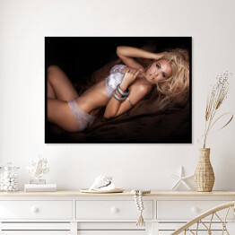 Plakat w ramie Seksowna blondynka w łóżku w pozycji leżącej