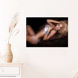 Plakat Seksowna blondynka w łóżku w pozycji leżącej
