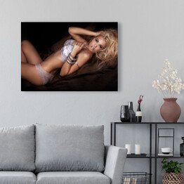 Obraz na płótnie Seksowna blondynka w łóżku w pozycji leżącej