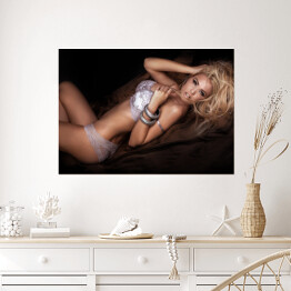 Plakat Seksowna blondynka w łóżku w pozycji leżącej