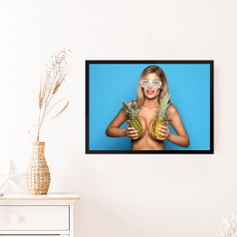 Obraz w ramie Uśmiechnięta kobieta trzymająca ananasy