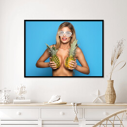 Plakat w ramie Uśmiechnięta kobieta trzymająca ananasy