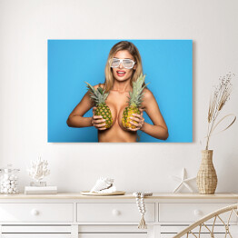 Obraz na płótnie Uśmiechnięta kobieta trzymająca ananasy