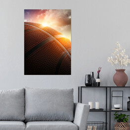 Plakat Piłka do koszykówki oświetlona zachodzącym słońcem