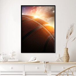 Plakat w ramie Piłka do koszykówki oświetlona zachodzącym słońcem