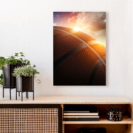 Obraz na płótnie Piłka do koszykówki oświetlona zachodzącym słońcem