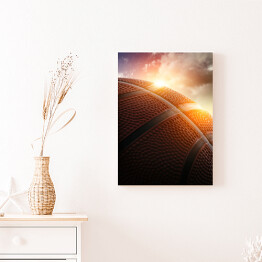 Obraz na płótnie Piłka do koszykówki oświetlona zachodzącym słońcem