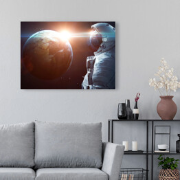 Obraz na płótnie Astronauta w kosmosie podziwiający Słońce wyłaniające się zza planety