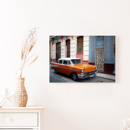 Obraz na płótnie Pomarańczowy amerykański samochod na przedmieściach Hawany