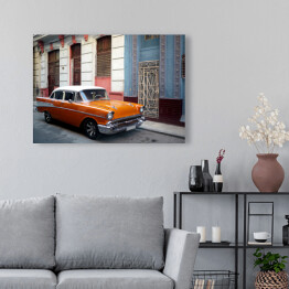 Obraz na płótnie Pomarańczowy amerykański samochod na przedmieściach Hawany