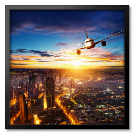 Obraz w ramie Samolot latający nad nowoczesnym miastem