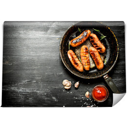 Fototapeta Smażone kiełbaski z czosnkiem i sosem pomidorowym na patelni