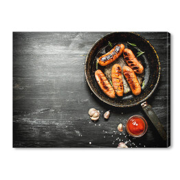 Obraz na płótnie Smażone kiełbaski z czosnkiem i sosem pomidorowym na patelni