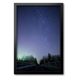 Obraz w ramie Nocne niebo pełne gwiazd, z mostem oświetlonym Zorzą Polaną rna pierwszym planie