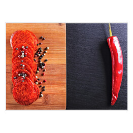 Salami z papryka chili i kolorowymi przyprawami na czarnym kamieniu i na drewnianej desce do krojenia