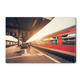 Obraz na płótnie Zabytkowa stacja kolejowa z czerwoną kolejką podczas zmierzchu w Niemczech