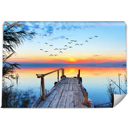 Fototapeta samoprzylepna Krajobraz jeziora z drewnianym pomostem podczas zachodu słońca