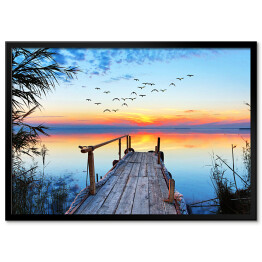 Plakat w ramie Krajobraz jeziora z drewnianym pomostem podczas zachodu słońca