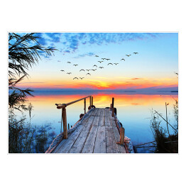 Plakat samoprzylepny Krajobraz jeziora z drewnianym pomostem podczas zachodu słońca