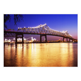 Most nad rzeką Mississippi w Luizjanie nocą z odbijającymi się od tafli wody światłami 