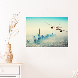 Plakat Samolot lecący nad miastem w sloneczny dzień