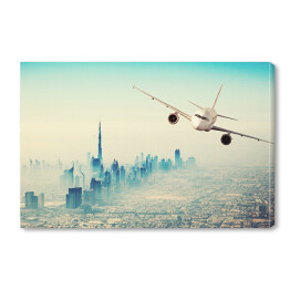 Obraz na płótnie Samolot lecący nad miastem w sloneczny dzień