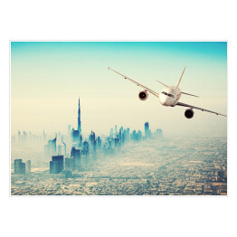 Plakat samoprzylepny Samolot lecący nad miastem w sloneczny dzień