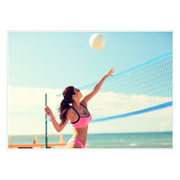 Plakat Młoda kobieta z piłką grająca w siatkówkę na plaży