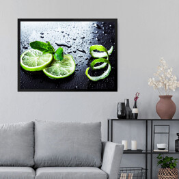 Obraz w ramie Zielone limonki z miętą i wodą spadające na czarnym tle