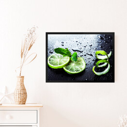Obraz w ramie Zielone limonki z miętą i wodą spadające na czarnym tle