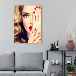 Obraz na płótnie Piękna blondynka z długimi kręconymi włosami, czerwonymi ustami i paznokciami