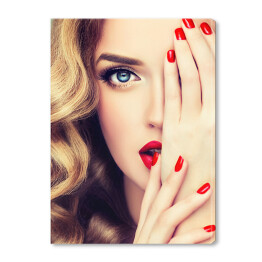 Piękna blondynka z długimi kręconymi włosami, czerwonymi ustami i paznokciami