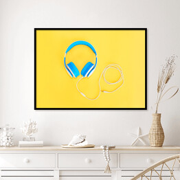 Plakat w ramie Niebieskie słuchawki leżące na żółtym tle