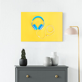 Obraz na płótnie Niebieskie słuchawki leżące na żółtym tle