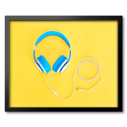 Obraz w ramie Niebieskie słuchawki leżące na żółtym tle
