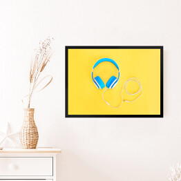 Obraz w ramie Niebieskie słuchawki leżące na żółtym tle