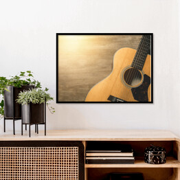 Plakat w ramie Gitara akustyczna oświetlona światłem słonecznym na drewnianym tle 