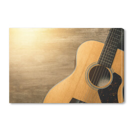 Obraz na płótnie Gitara akustyczna oświetlona światłem słonecznym na drewnianym tle 
