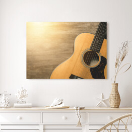 Obraz na płótnie Gitara akustyczna oświetlona światłem słonecznym na drewnianym tle 